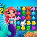 빨간 머리의 인어가 옆에 서 있고, 바다 생물 모양의 색색의 퍼즐 조각들이 배열되어 있는 게임 화면