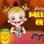 아기 소녀가 할로윈 테마의 공예품을 만들고 있으며, 테이블 위에 거미와 잭오랜턴이 있는 모습