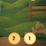 파란 공이 나무 울타리 옆의 초록 언덕 위에 있는 숫자 1과 2가 적힌 노란 공 위로 떨어지는 장면