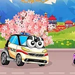 큰 눈을 가진 캐릭터로 꾸며진 경찰차와 분홍색 자동차가 벚꽃이 핀 도로에 있는 모습