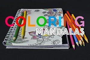 색연필과 색칠된 만다라 패턴이 있는 스케치북