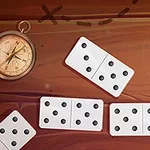 나침반과 여러 개의 도미노 조각이 갈색 배경 위에 흩어져 있다