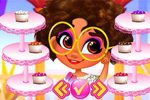 큰 안경을 쓴 소녀가 여러 층의 컵케이크 스탠드와 함께 있는 모습