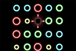 검은 배경 위에 빨간색, 노란색, 녹색, 하늘색의 광택나는 원과 원형 무늬가 배열되어 있다