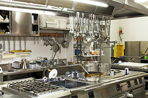 상업용 주방에 다양한 조리 도구와 주방 기구들이 정리되어 있는 모습