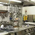 상업용 주방에 다양한 조리 도구와 주방 기구들이 정리되어 있는 모습