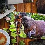 퍼즐 테이블 위에 달리는 말 그림 조각과 커피 잔이 놓여 있는 장면