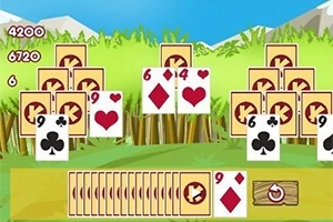 일련의 카드 더미가 풀밭 배경 위에 배열되어 있고, 하단에는 여러 카드가 나열되어 있는 장면