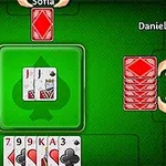 초록 테이블 중앙에 놓인 카드와 세 명의 플레이어 손패가 보이는 이미지