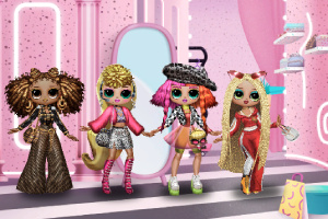 화려한 의상을 입고 다양한 헤어스타일을 가진 네 명의 인형이 핑크색 배경 앞에 서 있는 모습