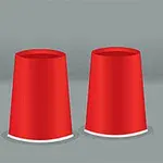 빨간 컵 세 개가 거꾸로 놓여 있고, 하나의 컵 앞에 노란 공이 있습니다