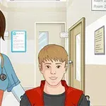 병원 복도를 배경으로 의료진이 휠체어에 앉은 소년을 밀고 가는 모습