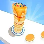 높게 쌓인 팬케이크 위에 시럽이 뿌려져 있고, 색색의 톱핑이 올려져 있으며, 두 개의 팬케이크가 옆에 놓여 있는 모습