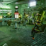 바 안에 여러 로봇들이 앉아 있는 레트로 분위기의 카페 내부 모습