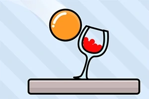 주황색 공이 빨간 액체가 담긴 와인잔 근처에 있는 모습