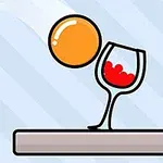 주황색 공이 빨간 액체가 담긴 와인잔 근처에 있는 모습