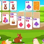 초원 배경에 놓인 카드 게임 이미지와 나무, 꽃 주위에서 토끼와 닭이 있는 풍경