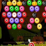 주황색, 초록색, 분홍색 공과 검은색 호박 이미지가 밤 배경의 집 앞에 배열되어 있음