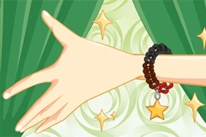 초록 커튼 앞에서 별 모양 장식이 달린 팔찌를 착용한 손