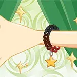 초록 커튼 앞에서 별 모양 장식이 달린 팔찌를 착용한 손