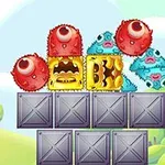 알록달록한 괴물 모양의 블록들이 회색 금속 상자 위에 쌓여 있는 모습