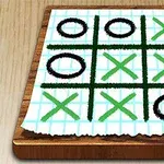 종이 위의 격자무늬에 검은색 동그라미와 초록색 엑스 표시가 그려져 있는 이미지