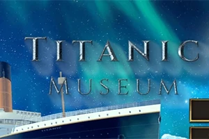 타이타닉 뮤지엄이라는 글자가 북극광이 비치는 밤하늘을 배경으로 선명하게 나타나고, 배의 일부분이 보인다