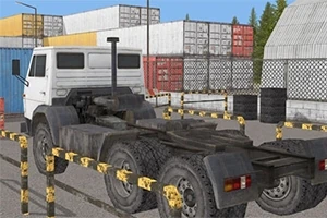 하얀 트럭이 컨테이너와 울타리로 둘러싸인 주차장에 주차되어 있는 모습