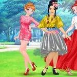 세 명의 여성이 다양한 색상의 드레스를 입고 공원에서 포즈를 취하고 있는 모습