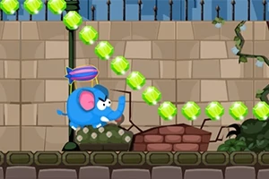 파란 코끼리가 날개를 달고 벽 앞을 지나며 초록색 보석들이 줄지어 있는 모습