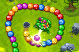 초록색 개구리가 잔디밭에서 다양한 색상의 구슬을 쏘고 있는 모습